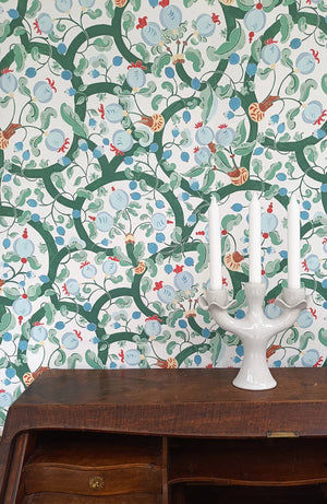 Albane wallpaper by Claire de Quénetain in green and blue, a hand-painted floral design above a sideboard