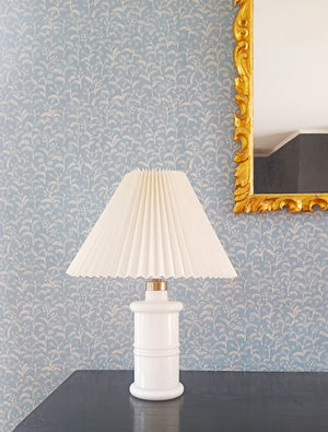 Margaux wallpaper by Claire de Quénetain in grey, delicate sprigs above a cabinet