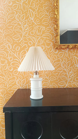 Celeste wallpaper by Claire de Quénetain in yellow, swirling leaf scrolls above a sideboard