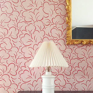 Paola wallpaper by Claire de Quénetain in pink and red, looping line work above a sideboard