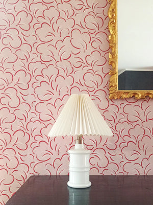 Paola wallpaper by Claire de Quénetain in pink and red, looping line work above a sideboard