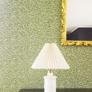 Margaux wallpaper by Claire de Quénetain in green, delicate sprigs above a sideboard