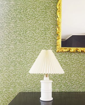 Margaux wallpaper by Claire de Quénetain in green, delicate sprigs above a sideboard