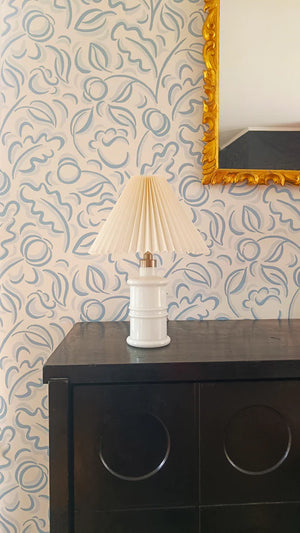 Faustine Blue wallpaper by Claire de Quénetain in blue, leafy scrolls above a sideboard