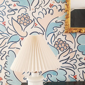 Leopolde wallpaper by Claire de Quénetain in pink and blue, a hand-painted floral design above a sideboard