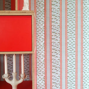 Hélène Red wallpaper by Claire de Quénetain in blue and red, striped bands above a sideboard