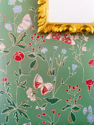 Josepha wallpaper by Claire de Quénetain in green, scattered flowers and birds in a styled room setting