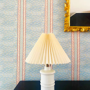 Mia wallpaper by Claire de Quénetain in pink, fine stripes above a sideboard
