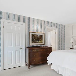 Ivy wallpaper by Annika Reed in blue, ivy trails and stripes in a bedroom