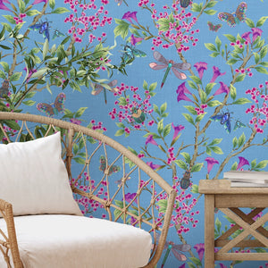 Jewel a Flutter wallpaper by Brand McKenzie in blue, birds and blossoms behind a sofa in a living room
