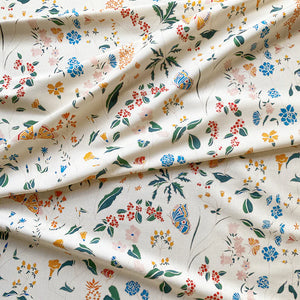 Josepha linen by Claire de Quénetain in cream, draped, showing scattered flowers and birds