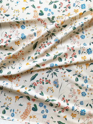 Josepha linen by Claire de Quénetain in cream, draped, showing scattered flowers and birds