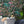 Jungle Life wallpaper by Brand McKenzie in pink and turquoise, pattern detail of jungle animals in dense foliage