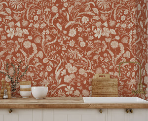 The Lost Garden wallpaper by Studio Le Cocq in terracotta, a dense garden of flowers above a sideboard