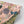 Les Plumes wallpaper by Tatie Lou in pink, partly unrolled roll showing exotic birds and blooms