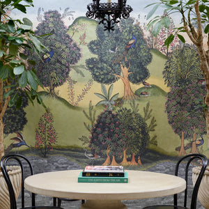 Mayura Valley wallpaper by Deus ex Gardenia in sage green and yellow, a peacock valley mural in a dining area