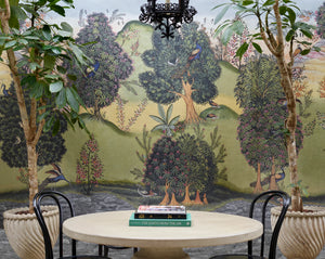 Mayura Valley wallpaper by Deus ex Gardenia in sage green and yellow, a peacock valley mural in a dining area