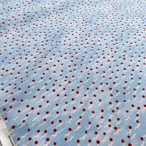 Malo linen by Claire de Quénetain in red, draped, showing scattered tiny motifs