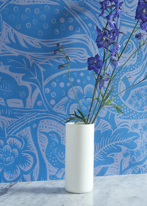 Wren wallpaper by St. Jude's in blue, wrens among leaves behind a console table