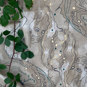 Metamorphasis linen by The Monkey Puzzle Tree in grey and green, draped, showing a metamorphosis design