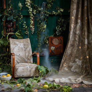 Metamorphasis linen by The Monkey Puzzle Tree in grey and green, a metamorphosis design on an upholstered chair