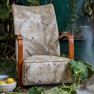 Metamorphasis linen by The Monkey Puzzle Tree in grey and green, a metamorphosis design upholstered on an armchair