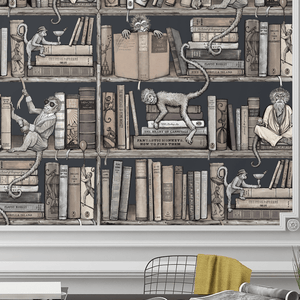 Monkey Library wallpaper by Brand McKenzie in taupe, monkeys in a bookcase behind a desk in a home office
