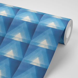 Motif wallpaper by Tatie Lou in blue, roll showing geometric pyramids