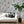 Newtown Creek wallpaper by XV Interiors in grey, drifting feathers behind a sofa in a living room