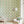 Sustainable Olive and Dot Peacock wallpaper by Seed Home Designs in blue and green in a living room