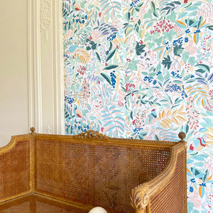 Olympia wallpaper by Claire de Quénetain in pink and red, a hand-painted floral design in a styled room setting
