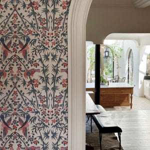 Palamara wallpaper by Deus ex Gardenia in blue and red, mirrored birds and flowers in a hallway
