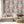 Painting in Colour wallpaper by Brand McKenzie in pastel, painterly floral clouds behind a sofa in a living room