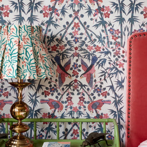 Palamara wallpaper by Deus ex Gardenia in blue and red, mirrored birds and flowers in a bedroom