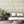Pampas Grass wallpaper by Brand McKenzie in grey, pampas grass plumes behind a bed