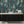 Peacock Manor wallpaper by Brand McKenzie in indigo blue, peacocks and arched windows above a sideboard