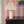 Pio wallpaper by Claire de Quénetain in red, fine stripes above a cabinet