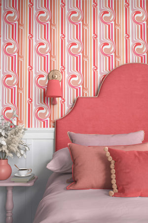 Popsicle wallpaper by Liberty James Studio in pink and coral, partly unrolled roll showing wavy popsicle stripes