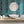 Popsicle wallpaper by Liberty James Studio in teal, wavy popsicle stripes behind a bed