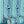 Popsicle wallpaper by Liberty James Studio in teal, wavy popsicle stripes behind a sofa in a living room