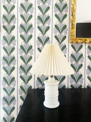 Raoul wallpaper by Claire de Quénetain in blue, leaf-motif stripes behind a console table