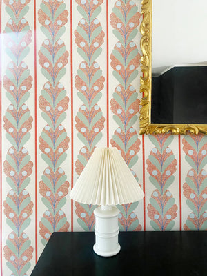 Raoul wallpaper by Claire de Quénetain in red, leaf-motif stripes above a sideboard