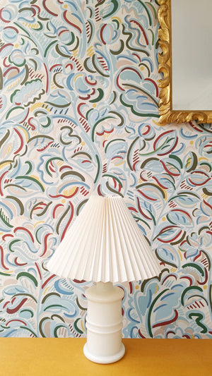 Raphaelle wallpaper by Claire de Quénetain in blue, a hand-painted floral design behind a console table