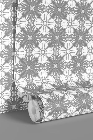 Santorini Tile wallpaper by Liberty James Studio in grey, partly unrolled roll showing a Mediterranean tile pattern