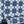 Santorini Tile wallpaper by Liberty James Studio in indigo, partly unrolled roll showing a Mediterranean tile pattern