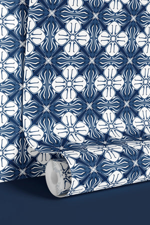 Santorini Tile wallpaper by Liberty James Studio in indigo, partly unrolled roll showing a Mediterranean tile pattern