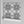 Santorini Tile wallpaper by Liberty James Studio in grey and white, partly unrolled roll showing