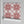 Santorini Tile wallpaper by Liberty James Studio in pink and white, partly unrolled roll showing