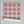 Santorini Tile wallpaper by Liberty James Studio in pink, partly unrolled roll showing a Mediterranean tile pattern