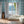 Santorini Tile wallpaper by Liberty James Studio in pale blue and white, a Mediterranean tile pattern in a bathroom setting